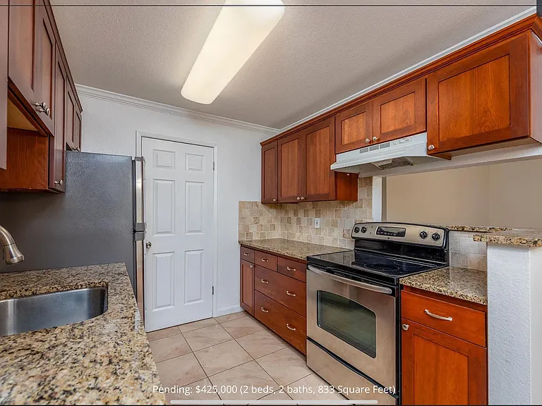 Granite counter top and cherry cabinets. Door is to the stackable washer and dryer.