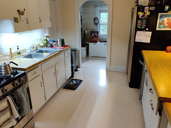 Kitchen with laundry room beyond arched doorway