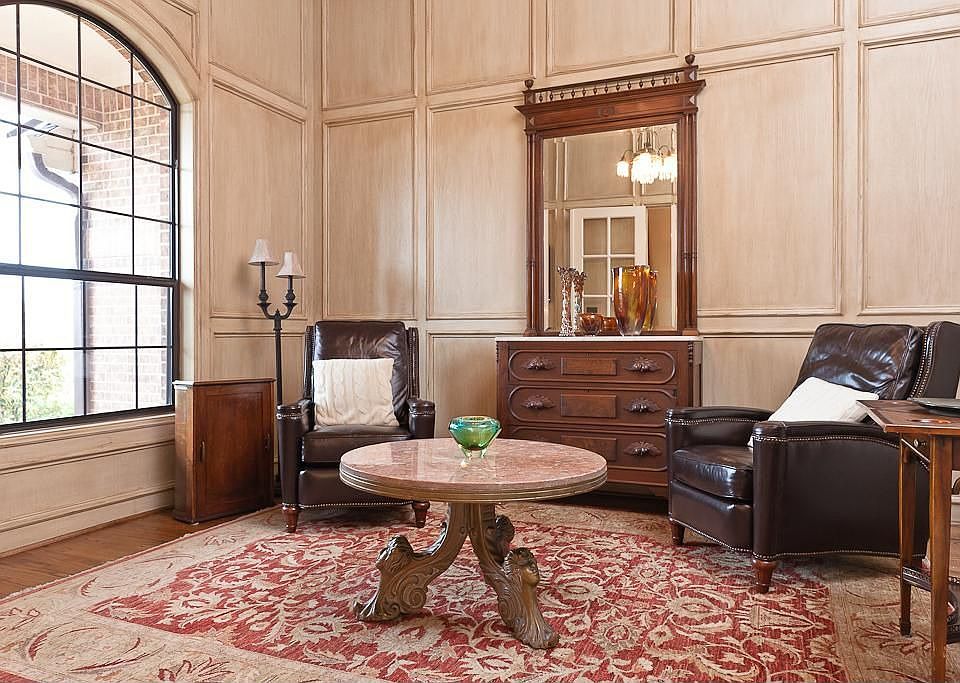 Study has custom paneling, hardwood flooring, and antique chandelier.