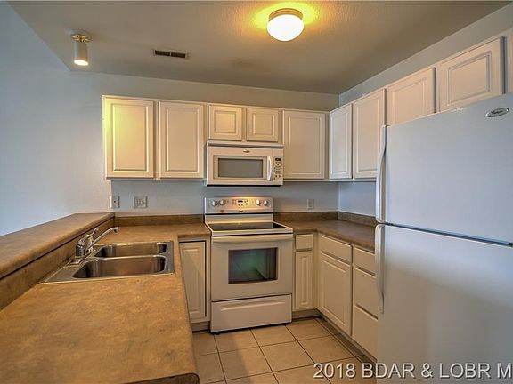 The kitchen holds a full complement of appliances, and features a breakfast bar.