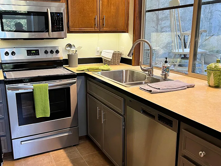 Stainless appliances. Ultra quiet dishwasher. Side-by-side refrigerator. Smooth top stove. Double stainless sinks with sprayer faucet. Tall windows and high ceiling make it a pleasure to cook.