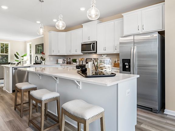 Open kitchen an adjacent living room at a DRB Homes Upton II model home at the Canterbury Station co