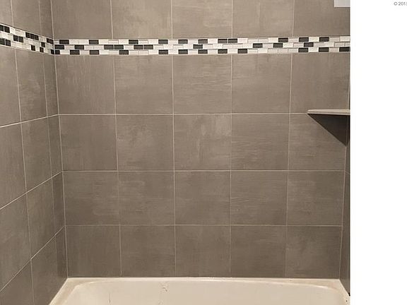 2nd bath on main level has lovely tile shower/tub surround detail.