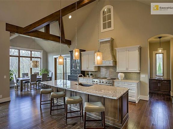 The kitchen area boasts a huge island, granite counters, Viking range, oven, and hood, and soft-close drawers and cabinets.