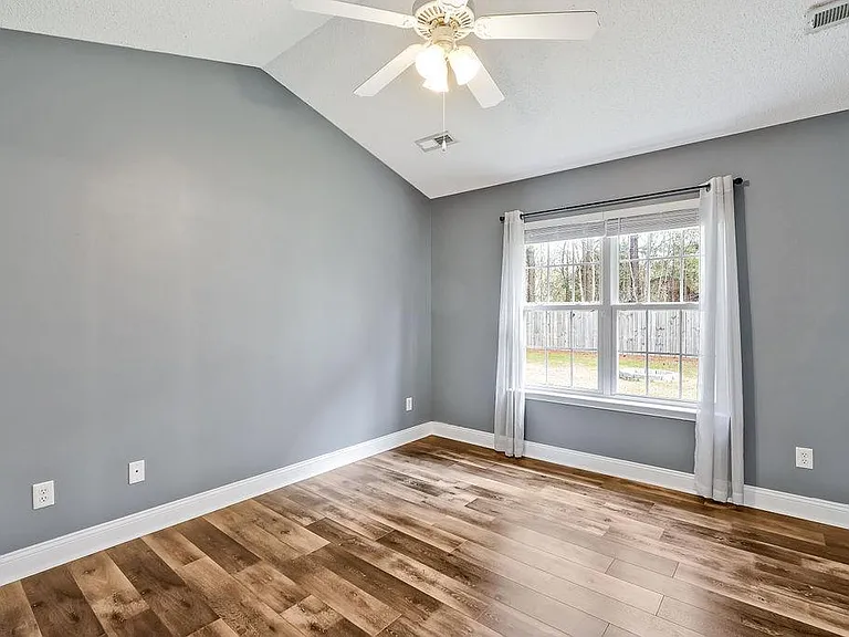 Master bedroom with vaulted ceilings. Window to the backyard.