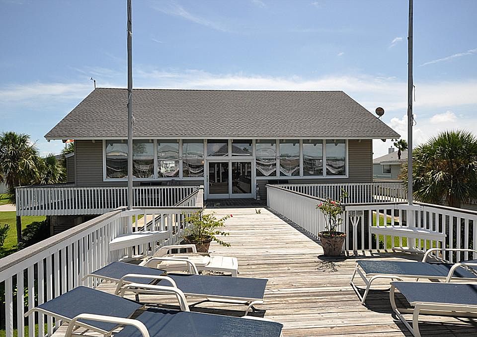  Spacious covered decks off the living room and uncovered deck space over the boat house offers great space for sunbathing over the water or seating for large family gatherings and parties.  Note the corner built-in seating and flag poles.