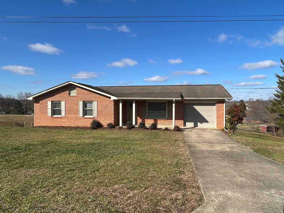 House front, with driveway and single car garage.