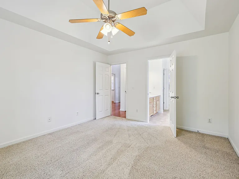 Main floor primary bedroom with tray ceiling