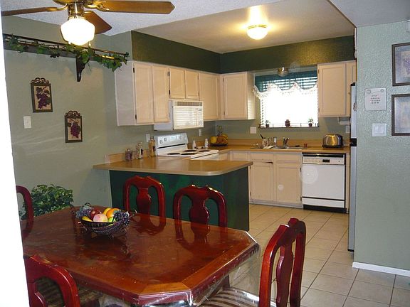 open kitchen with breakfast bar, dining area and built-in microwave