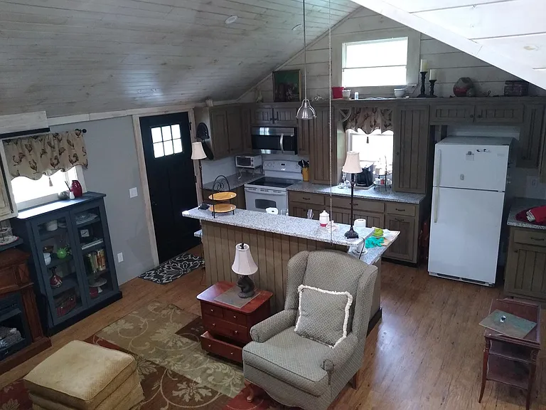 Looking down from loft stairs black door on left leads to grilling deck