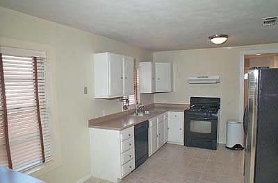 Kitchen with Ceramic Tile Flooring, Updated Countertops, and Stainless Steel Refrigerator