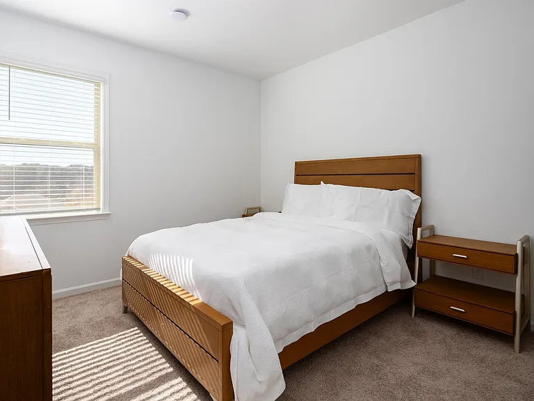 Third bedroom with a queen-size bed and abundant natural light streaming through the window.
