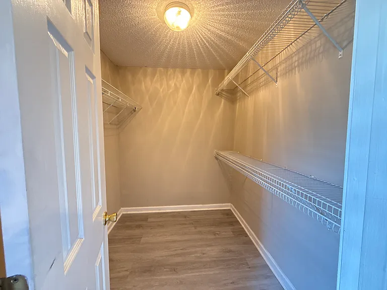 Large master walk-in closet with built-in shelving and plenty of organized storage space.