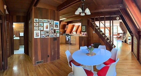 Dining room with view of bathroom on left, and kitchen and living room on the right. Staircase leads to upstairs bedroom.