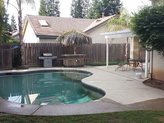 Backyard includes grass area, pool, eating island and two pa