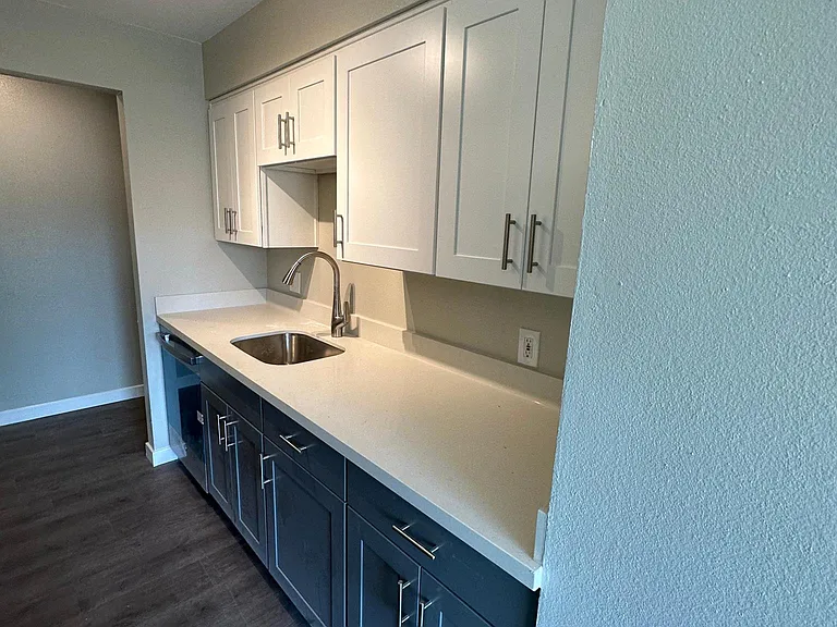 Kitchen with new quartz countertop and cabinets. Dishwasher, stove range, microwave, and big size refrigerator