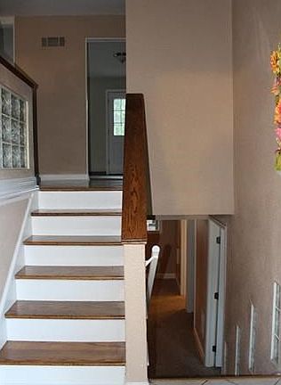 Entry foyer is ceramic with wooden steps leading to the main level of the home and carpeted steps leading to the lower level