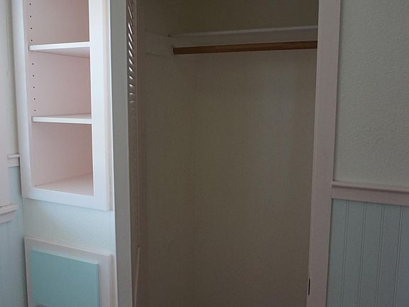 A bedroom closet with built in drawers and shelves.