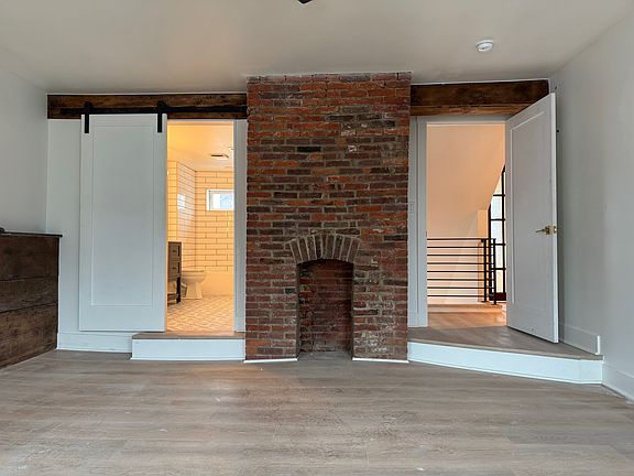 2nd floor bedroom with bathroom to the left and entry door to the hallway on the right side of fireplace