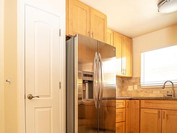 Apt 4, kitchen - refrigerator, door to pantry. Second entry door, direct to kitchen, is at left just out of view of this picture.