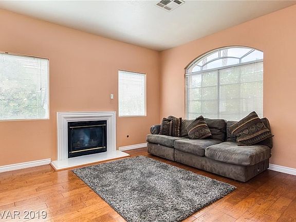 Living room has a fireplace and wood floors..