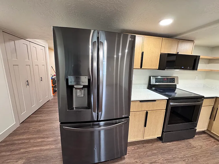 Modern kitchen featuring stainless steel French-door refrigerator, sleek cabinetry, and clean finishes.