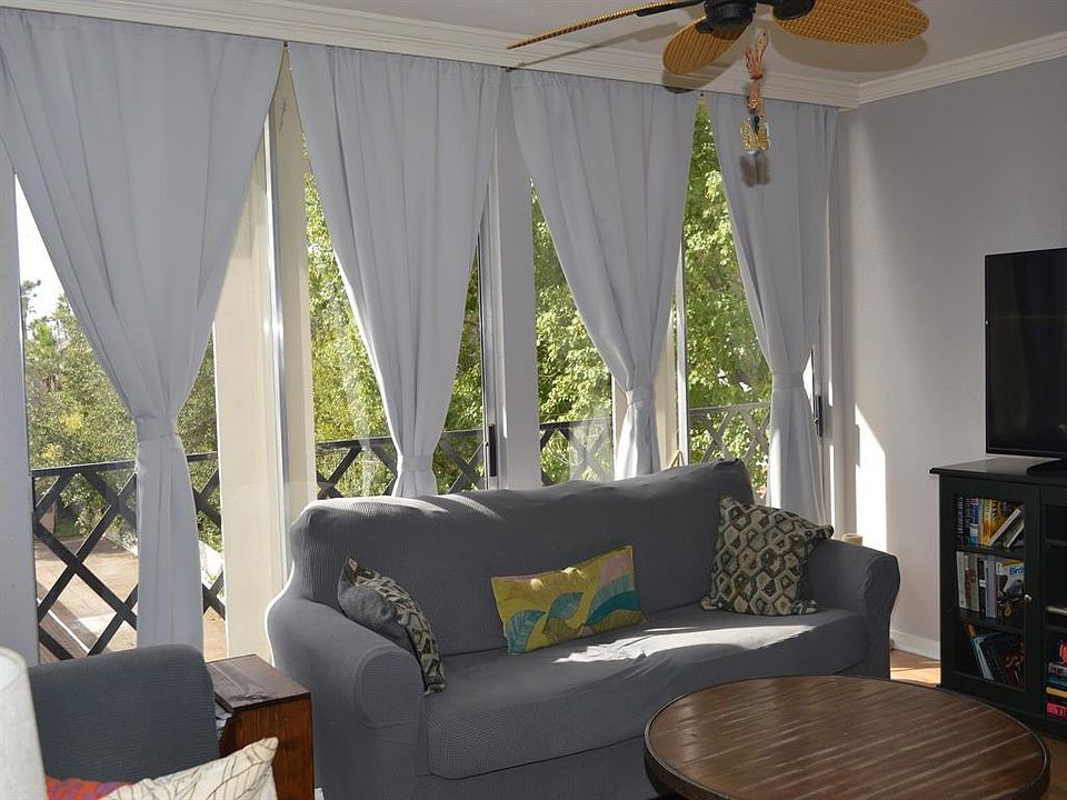 Living room has a wall of windows with sliding glass door to a "juliette"balcony. Enjoy tree top views out every window in the condo