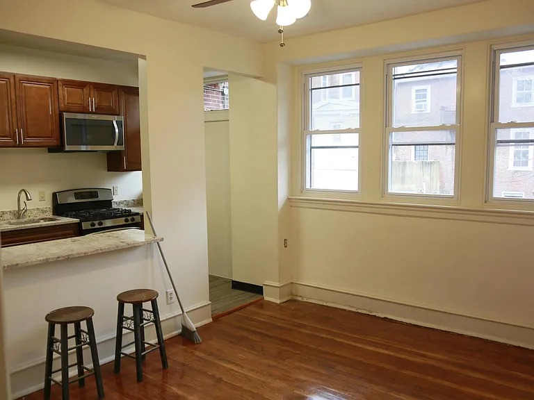 small counter space, a door in the kitchen that leads to the parking lot. living room with three windows/screens.