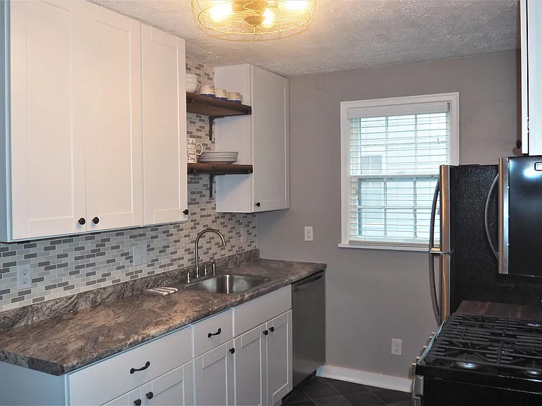 New kitchen. White, cream and gray colors. Stainless steel, brand new appliances including dishwasher, fridge, microwave and 5 burner gas stove.