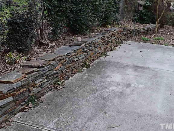 Stacked stone wall along the parking pad