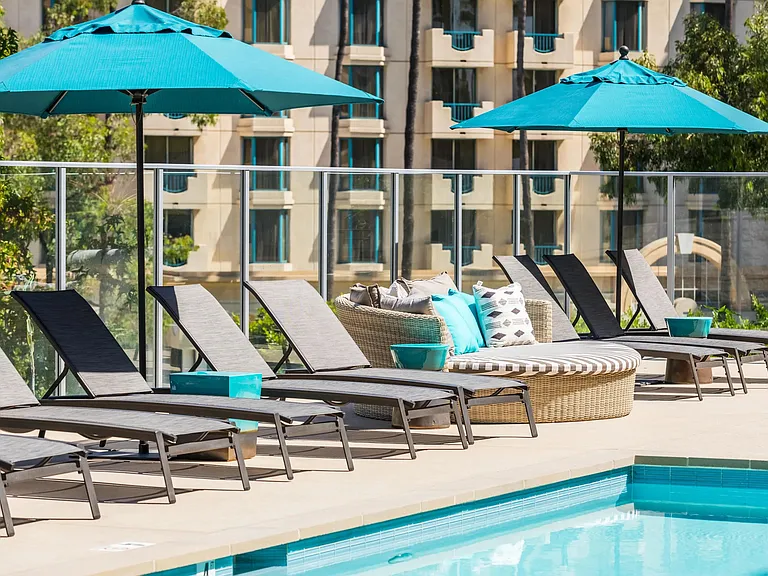 Poolside seating with shaded daybeds for unwinding in the sun.