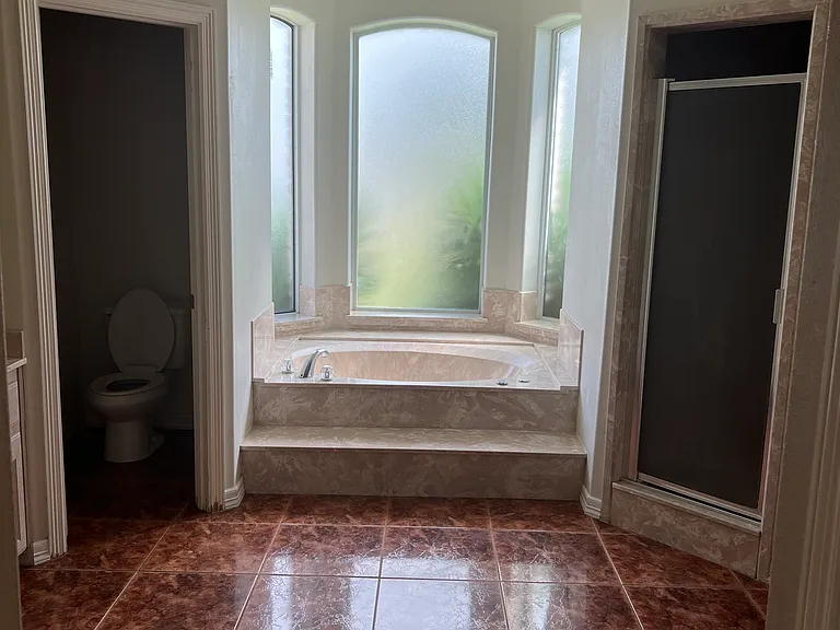 Spacious ensuite bathroom featuring a relaxing soaking tub, separate walk-in shower, and private toilet area _ designed for comfort and convenience.