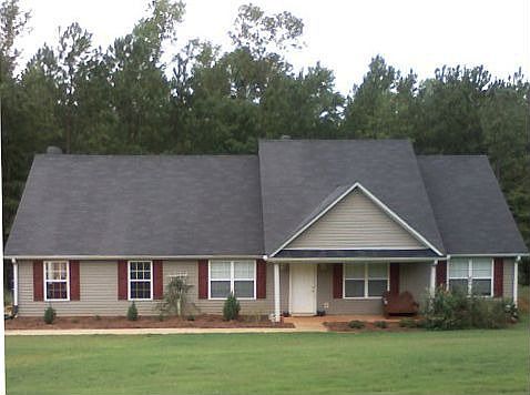 See the large front yard with new bermuda sod and trees in the back.