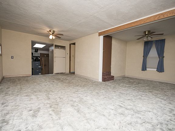 Open floor plan with dining room (12x11) flowing to the spacious living room (11x29). Ceiling fans in both rooms and newer vinyl windows throughout the home.  This cute and clean open space is just waiting for your finishing touch to make it your own and call it home!