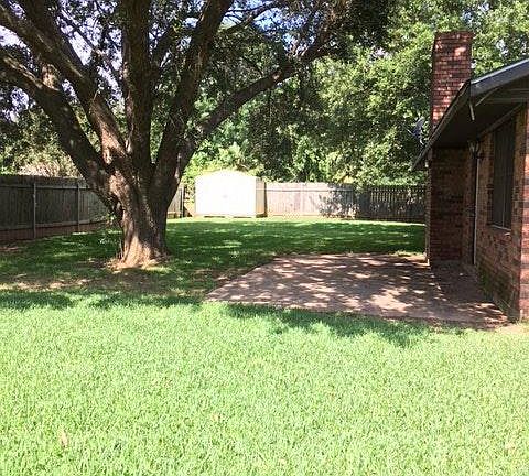 Large shady yard with patio and storage building