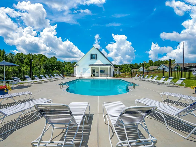Resort-style pool with ample seating, lounge chairs and umbrellas.