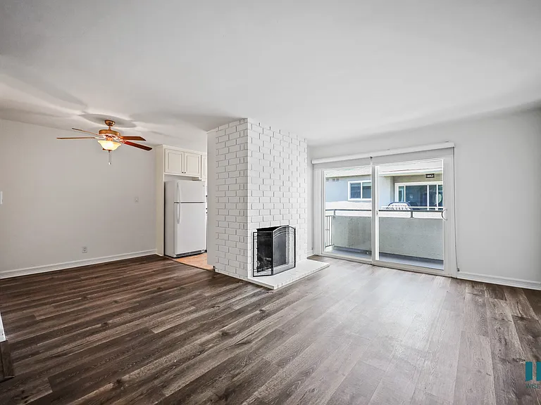 Open-Concept Dining and Living Room with Vinyl Flooring, Fireplace, and Patio