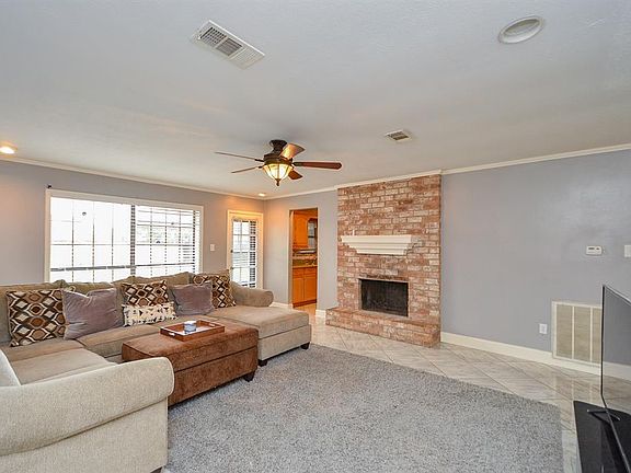 Living room with a wood burning fireplace, that offers a beautiful view of the backyard.