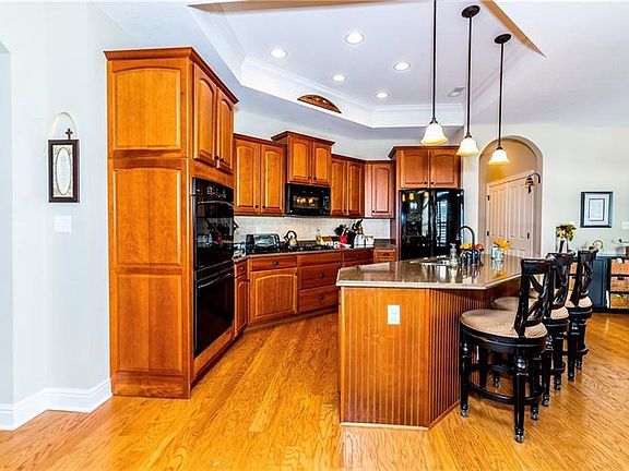 The kitchen has a giant granite island with counter seating for 3 or more stools, gas cook top and double oven, tray ceiling wit