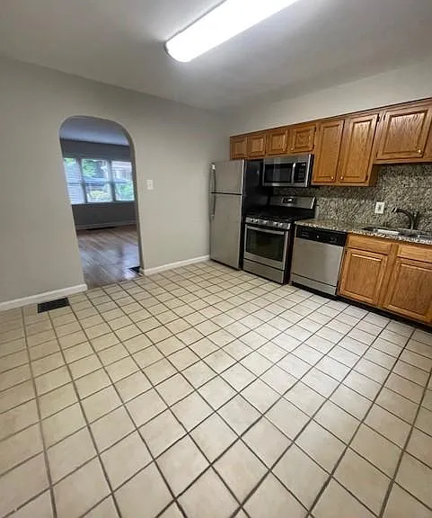 Kitchen has cute arched doorway going into living room.