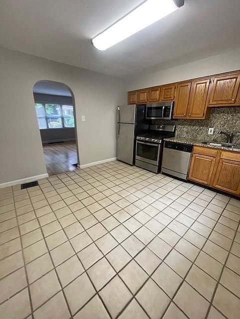 Kitchen has cute arched doorway going into living room.