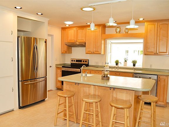 Open-concept pristine kitchen. New stainless appliances, bar sink in island.