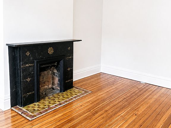 Living room with original decorative fireplace.