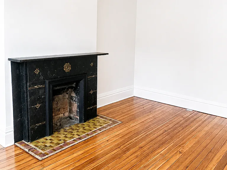 Living room with original decorative fireplace.