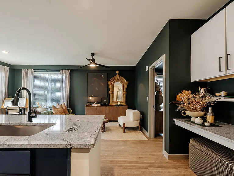 Modern apartment kitchen with granite countertops, built-in bar space, open-concept layout, and designer finishes.
