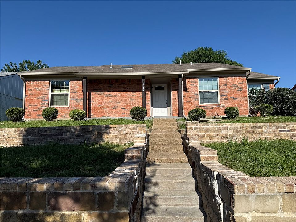 Red brick exterior featuring a covered entry and multiple windows