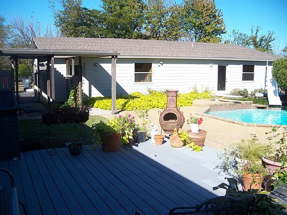 Side view of 3 car garage and pool house with kitchen and bath
