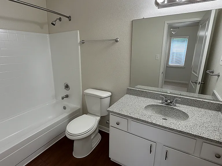 Bright and modern bathroom featuring sleek countertop, large mirror. Bright and modern bathroom featuring sleek countertop, large mirror.