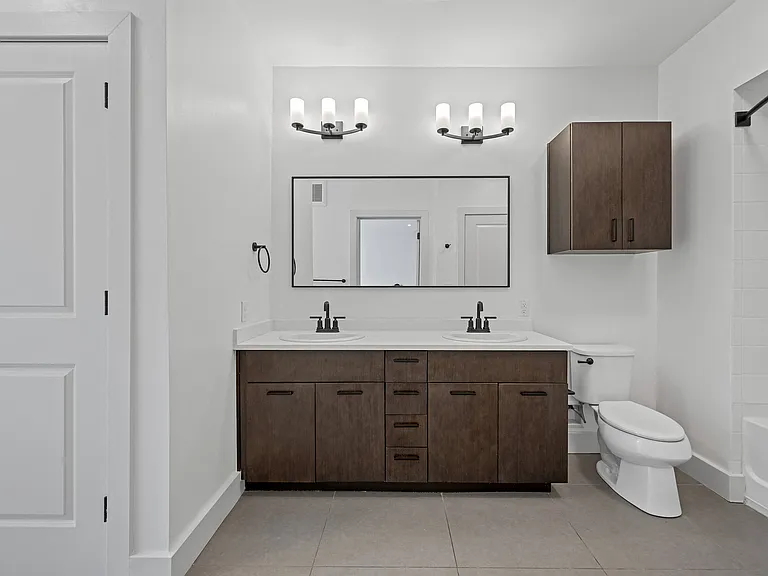 Double Sink Vanity with Dark Wood Cabinets and Sleek Black Fixtures