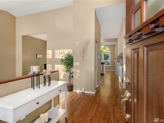 Open shaker style door to gleaming oak hardwoods. 